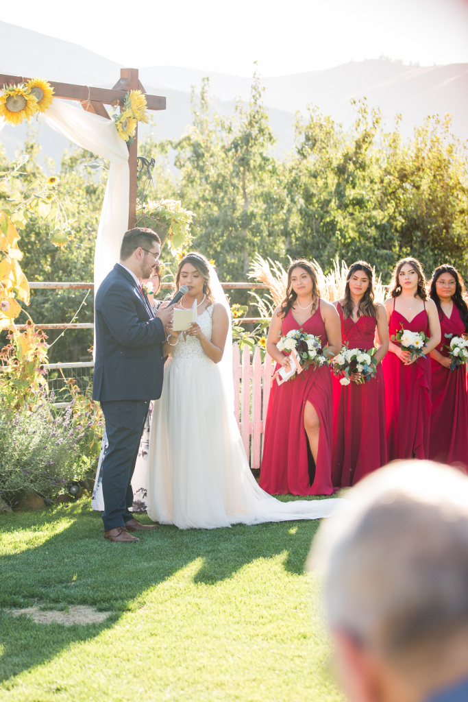 Bride sharing personal vows beneath sunflower arch, Wenatchee