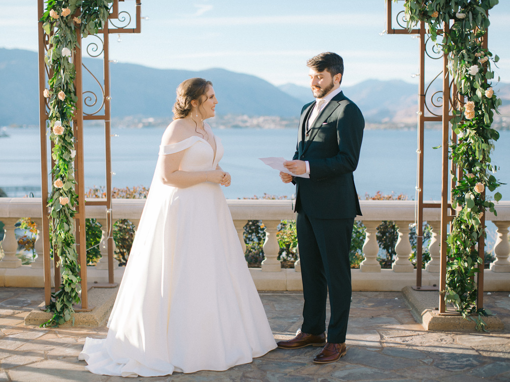 Groom sharing vows with smiling bride at Lake Chelan